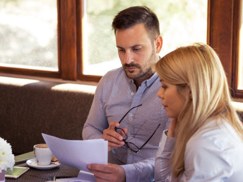 couple-studing-documents woman with a laptop smiling